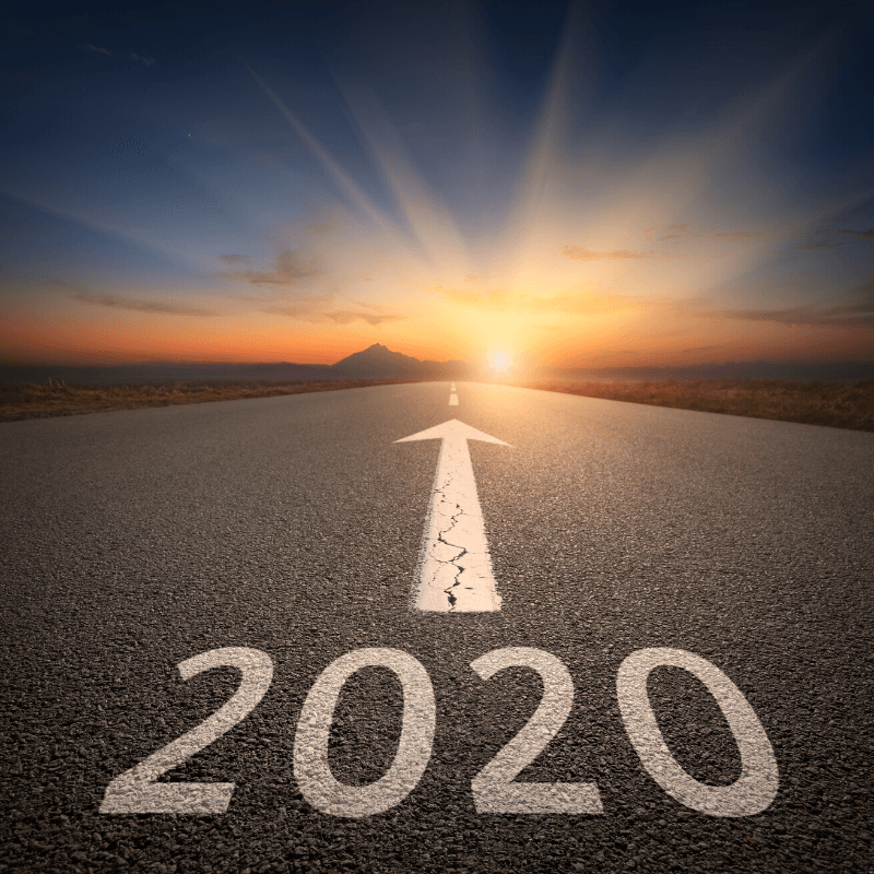 Photo of road into sunrise with 2020 on pavement
